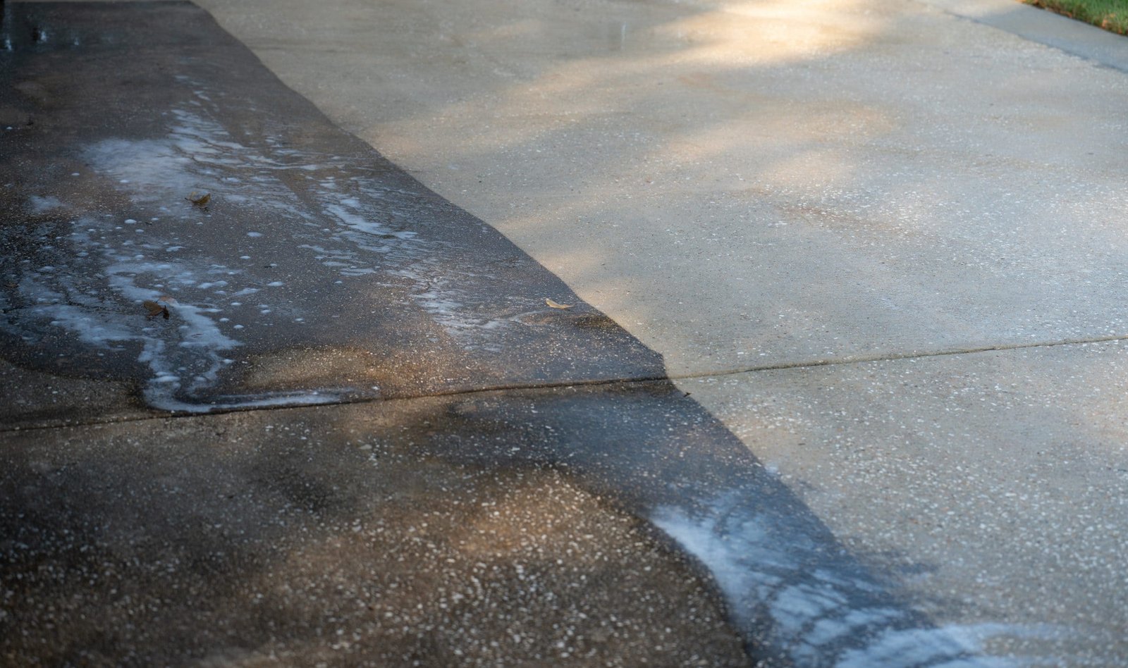 A concrete driveway with water running down it.