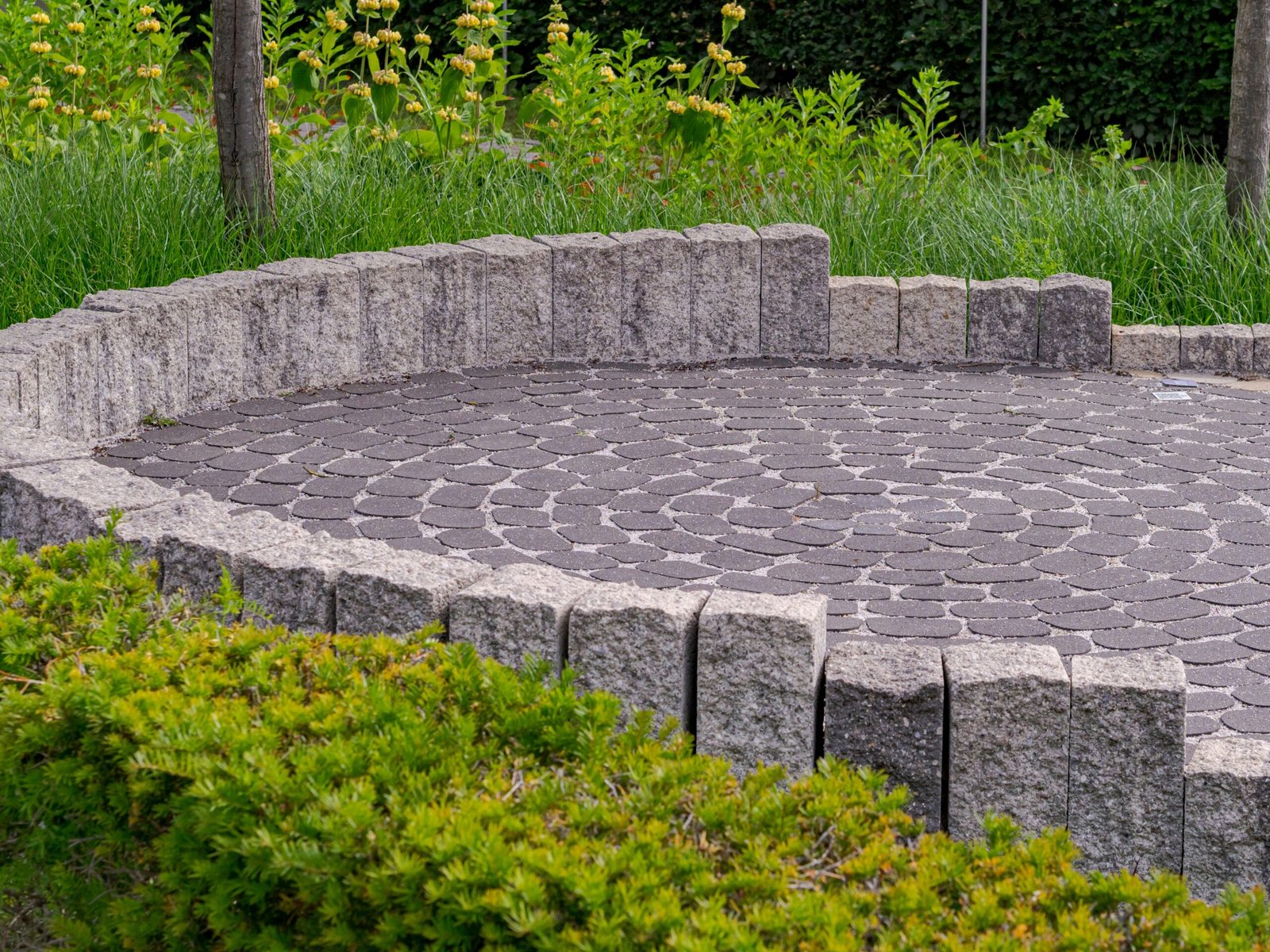 Circular fan-pattern paver patio bordered with granite block edging